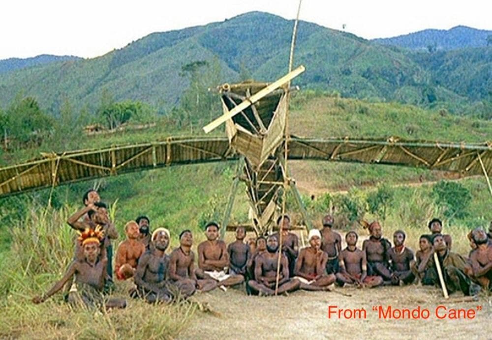 People posed in front of a bamboo airplane in a still from the 1962 film Mondo Cane.